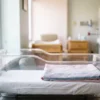 Crib sheets in use: white knitted fitted crib sheet on a hospital bassinet mattress by International Linens