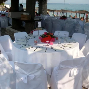 Round banquet tables with white tablecloths and chair covers