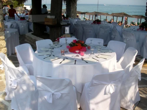 Round banquet tables with white tablecloths and chair covers