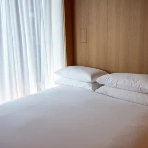 Hotel bed with white sheets and pillows