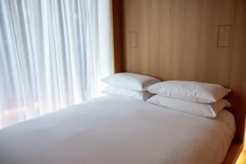 Hotel bed with white sheets and pillows