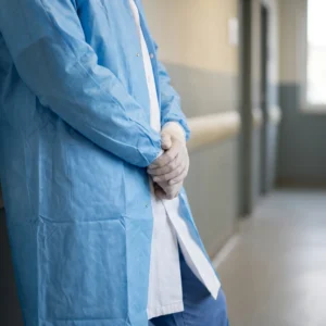 Lab coats and isolation gowns in use: white lab coat and blue reusable isolation gown by International Linens